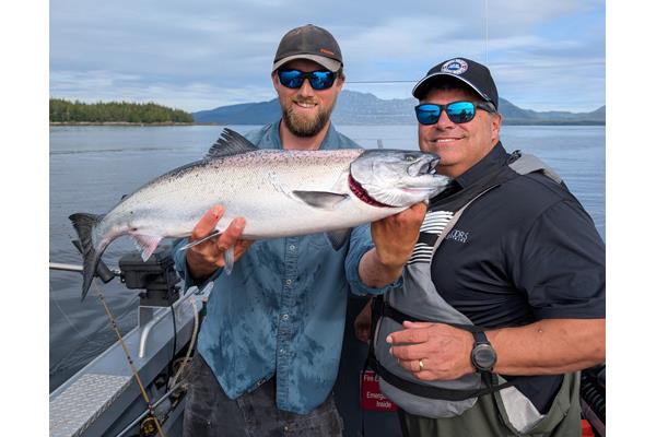 Chad Ogden, founder of QFloors, celebrating his King Salmon while fishing in Ketchikan, AK