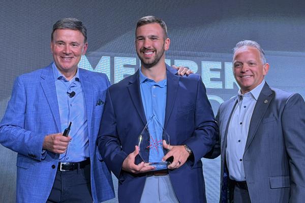 Tom Stacy with Contract Flooring accepting their award for Most Volume with Experius winner